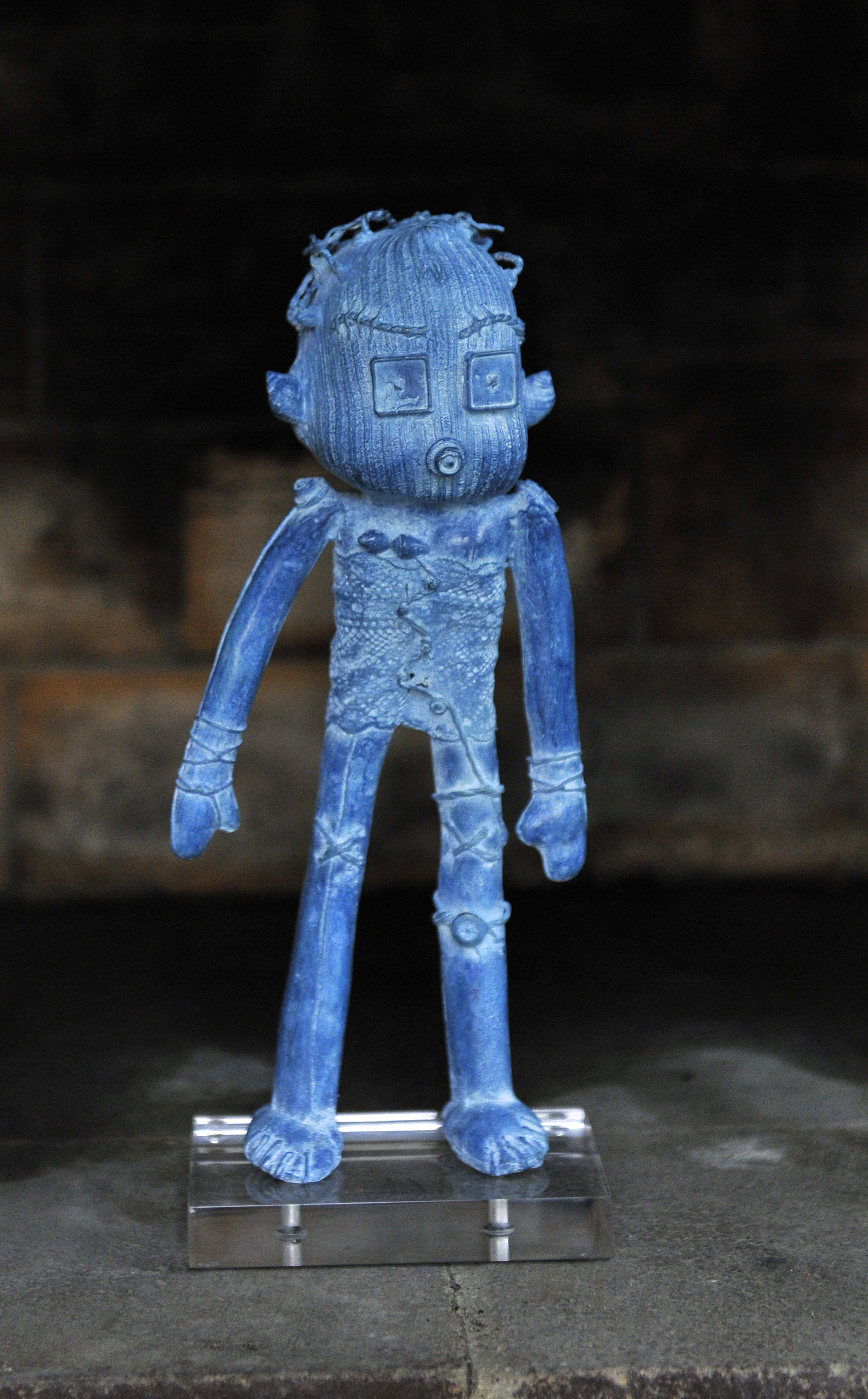 Doodle en bronce pintado de azul sobre fondo oscuro