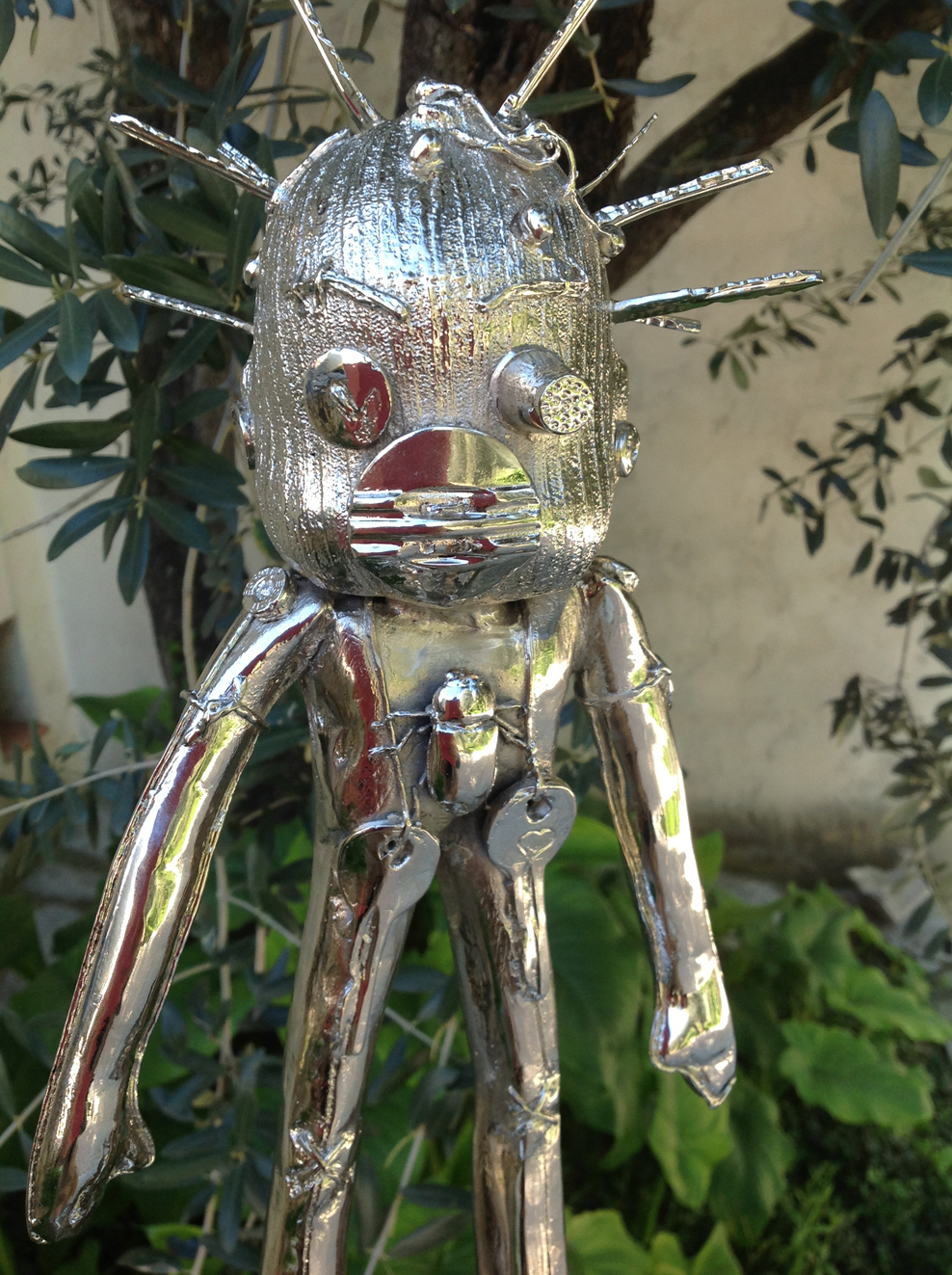 Doodle de bronce niquelado en un jardín de olivos